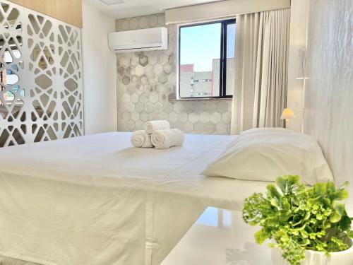 a white bedroom with a large bed with towels on it at Aconchego à Beira Mar (no melhor do Meireles) in Fortaleza