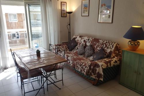 un salon avec un canapé et une table dans l'établissement Charming apartment 15 mins away from the Palais des Festivals, à Cannes