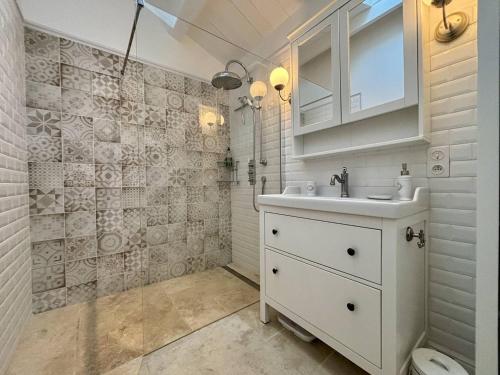 y baño blanco con lavabo y ducha. en Maison La Brée-les-Bains, 3 pièces, 4 personnes - FR-1-246A-285, en La Brée-les-Bains