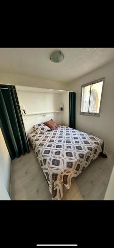 une chambre avec un lit avec une couette dessus dans l'établissement Appartement VALRAS-PLAGE bord de mer, à Valras-Plage