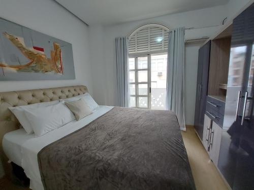 a bedroom with a large bed and a window at South Beach Copacabana in Rio de Janeiro