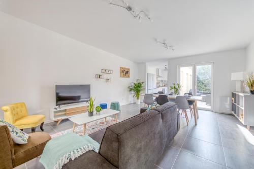 un salon avec un canapé et une télévision dans l'établissement Villa Spacieuse 6 ch/12 personnes/ 6 SDB WC privée, à Valenciennes