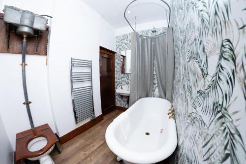 a bathroom with a white tub and a sink at Watermouth Castle, West Tower Apartment in Ilfracombe