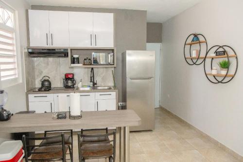 a kitchen with a table and a refrigerator at EcoMar Rentals in Cabo Rojo
