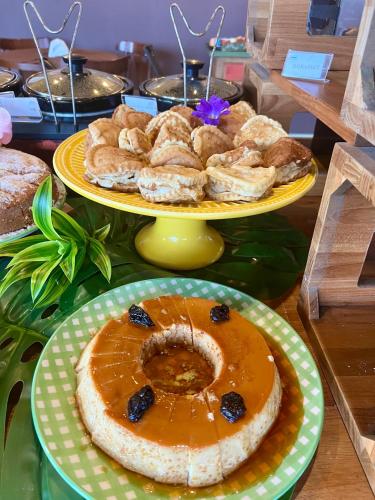 a table with two plates of pastries and pies at Pousada Praia Bela in Ilhéus