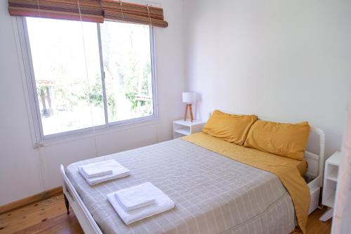 - une chambre avec un lit et 2 serviettes dans l'établissement Cabañas Chaná y Timbú, à Dique Luján