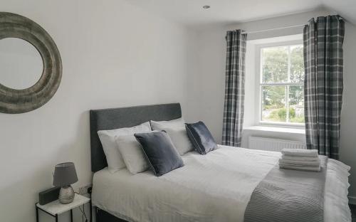 a bedroom with a bed with a mirror and a window at The Ben Bhraggie Inn in Golspie
