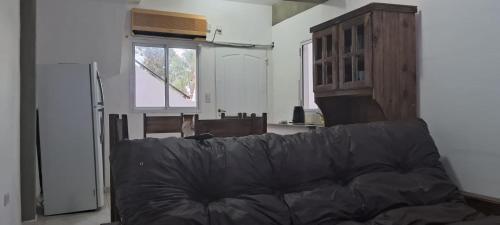 sala de estar con sofá negro y ventana en Dpto centrico en Bella Vista