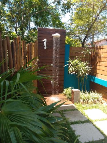 a garden with a water fountain next to a fence at Pousada Vila Guyrá in Florianópolis