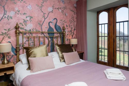 Un dormitorio con una cama con una pared rosa. en Watermouth Castle, Harbour Apartment, en Ilfracombe