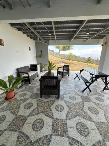 sala de estar con suelo de baldosa, mesa y sillas en Villa Celajes, en Barva