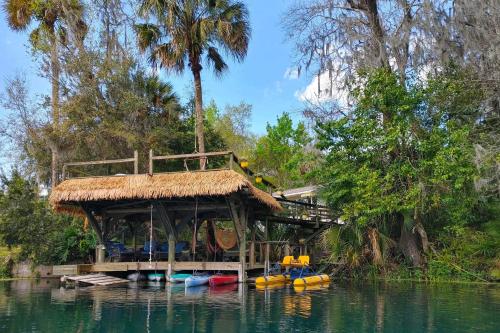 a house on a dock on a river with boats at Dock and Kayaks Riverfront Dunnellon Home! in Dunnellon