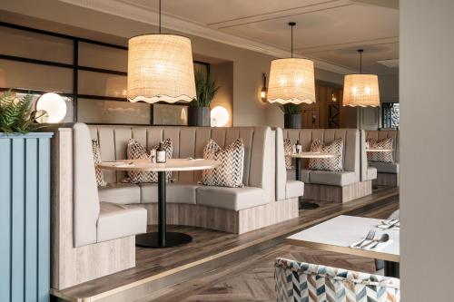 a restaurant with tables and chairs and chandeliers at Craig Manor in Bowness-on-Windermere