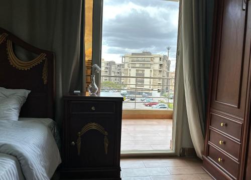 a bedroom with a bed and a window with a view at Cozy apartment New Cairo in New cairo