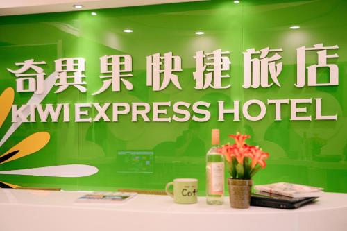 a green wall with a sign for a hotel at KIWI-Taichung Station Branch 1 in Taichung