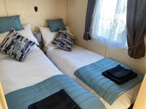 two twin beds in a room with a window at Static van on Smallgrove in Ingoldmells in Skegness