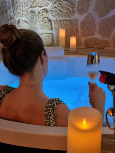 ル・グロー・デュ・ロワにあるLes Spas de la mer, Suite & Spa, Love room, Plein Cœur du Grauの椅子に座ってワインを飲む女性