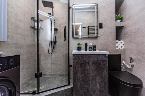 a bathroom with a shower and a toilet and a sink at Alpine serenity deLuxe apartment with MOUNTAIN views near the ADK shopping center and Sairan METRO station in Almaty