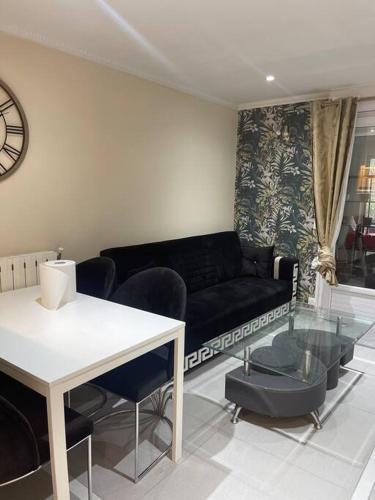 sala de estar con sofá negro y mesa en Appartement 3 pièces, en Épinay-sur-Seine