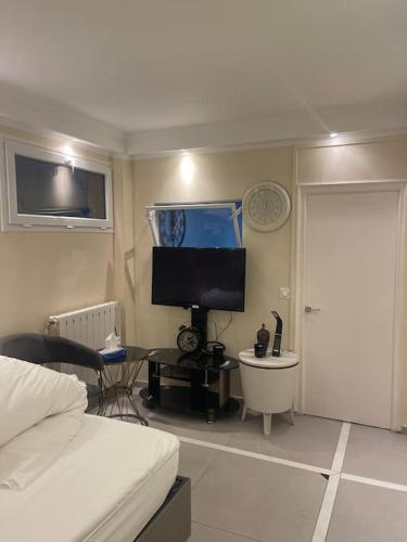 1 dormitorio con 1 cama y escritorio con TV en Appartement 3 pièces, en Épinay-sur-Seine