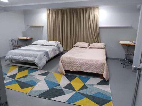 um quarto com 2 camas e um tapete colorido em Departamento amplio céntrico em Huaraz