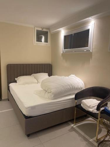 une chambre avec un lit, une télévision et une chaise dans l'établissement Appartement 3 pièces, à Épinay-sur-Seine