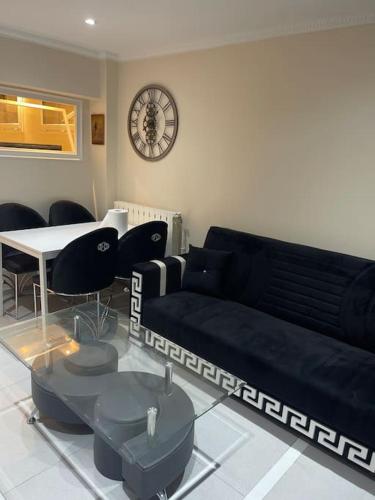 - un salon avec un canapé, des tables et un réveil dans l'établissement Appartement 3 pièces, à Épinay-sur-Seine