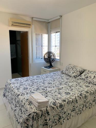 um quarto com uma cama com um edredão preto e branco em Apartamento 3 quartos equipado em Maceió