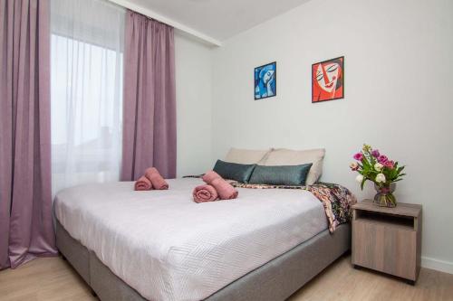 Un dormitorio con una cama con almohadas rosas. en Apartament Mały Książę, en Chełm