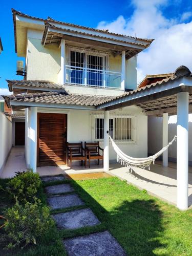 una casa con una hamaca en el patio en Casa Piscina em Condomínio 5min Praia ITACOATIARA., en Niterói