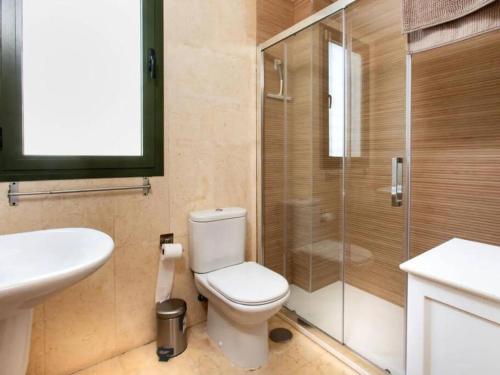 La salle de bains est pourvue de toilettes et d'une douche en verre. dans l'établissement Sunflower Appartment, à Nerja