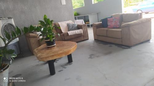 a living room with couches and a table with a plant at Pousada Venture Jalapao in São Félix do Tocantins