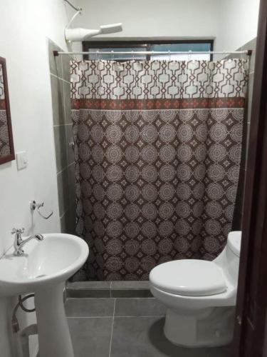 y baño con aseo y cortina de ducha. en BARI Campings resort, en Puerto Viejo