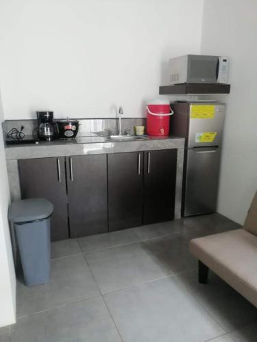 uma pequena cozinha com um lavatório e um balcão em BARI Campings resort em Puerto Viejo