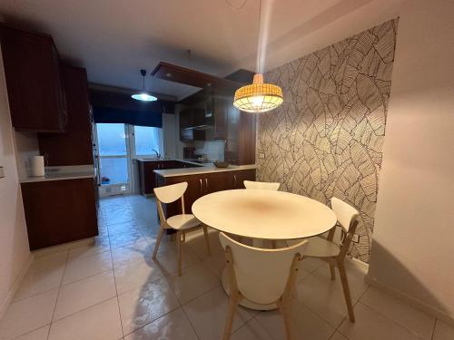 Una cocina y un comedor con mesa y sillas. en HOME GV35 By Oktheway, en Sarria