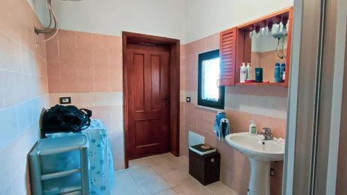 uma casa de banho com um lavatório, um WC e um espelho. em Casa Cristoforo Colombo em Sorso