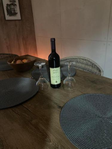 a bottle of wine sitting on a table with two glasses at Aja apartman Family lux Divčibare in Divčibare