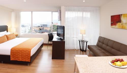 メデジンにあるEstelar Apartamentos Medellinのベッドとソファ付きのホテルルーム