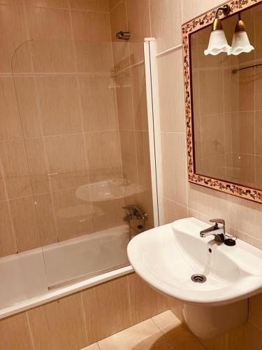 La salle de bains est pourvue d'un lavabo, d'une douche et d'un miroir. dans l'établissement Bonito Piso con 2 habitaciones, à Porto do Son