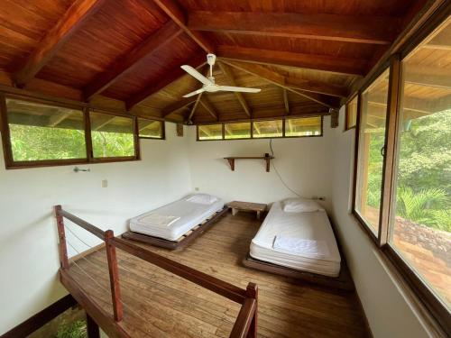 Habitación con 2 camas y ventilador de techo. en Villas Punta India, en Ostional