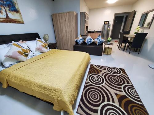 a bedroom with a bed and a living room at DELUXE ROOM Queen Bed & Sofa Bed with Balcony and Swimming Pool at PPS in Puerto Princesa City