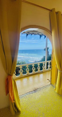a room with a window with a view of the ocean at Maison du Bonheur in Dakar