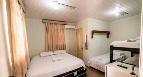 Habitación pequeña con 2 camas y escritorio. en HOTEL CENTRAL DE FORTALEZA en Fortaleza