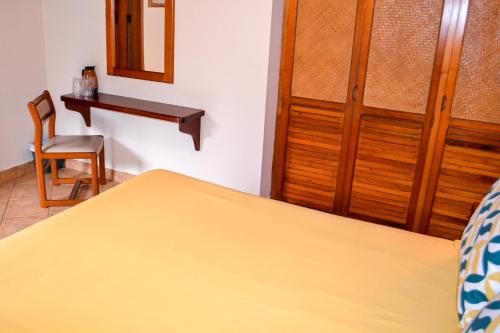 a bedroom with a bed and a table and a chair at El Tucano Resort & Thermal Spa in Quesada