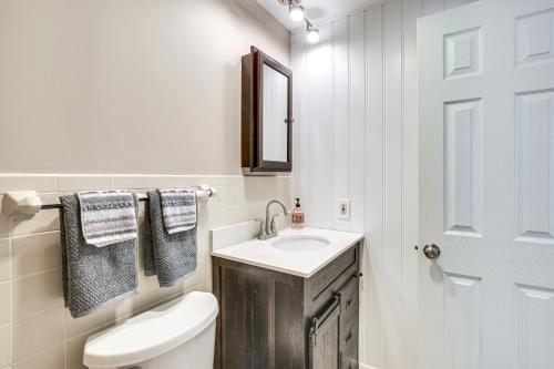 a bathroom with a sink and a toilet and a mirror at Ridgefield Cottage Walk to Town and Movie Theater! in Ridgefield