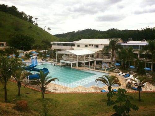 a resort with a large pool with a water slide at hotel fazenda encanto in Guararema