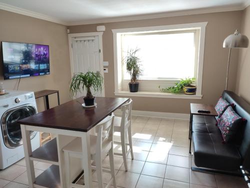 uma sala de estar com uma mesa e uma janela em Private Suite w King Bed, Ground Level, Naturally Bright em Vancouver