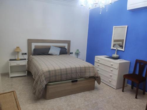 1 dormitorio con cama, tocador y espejo en Piso céntrico reformado de excelente ubicación en Vinarós