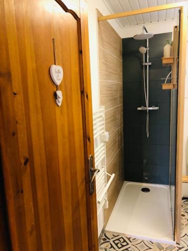 La salle de bains est pourvue d'une douche et d'une porte en bois. dans l'établissement Chalet à Gérardmer - Vue montagne - Calme & Paisible, à Gérardmer