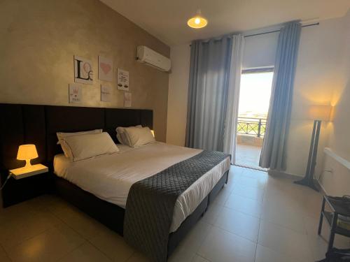 a bedroom with a bed and a large window at Spacious apartments with Sea view at Samarah Resort in Sowayma